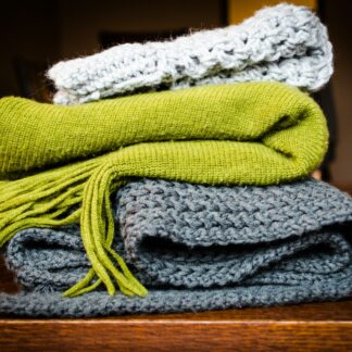 three gray, green, and white scarf on top of table