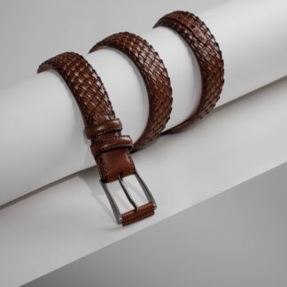 a pair of brown leather belts sitting on top of a white piece of paper