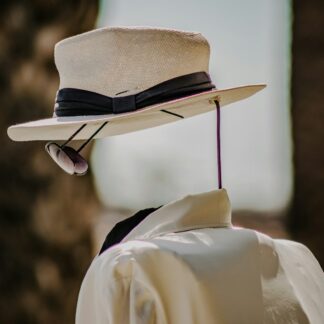 person wearing white dress shirt and brown fedora hat